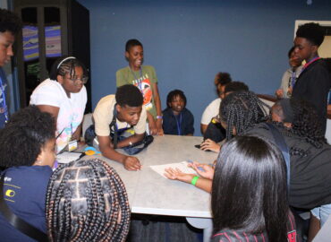Group of students interacting and laughin in a classroom.