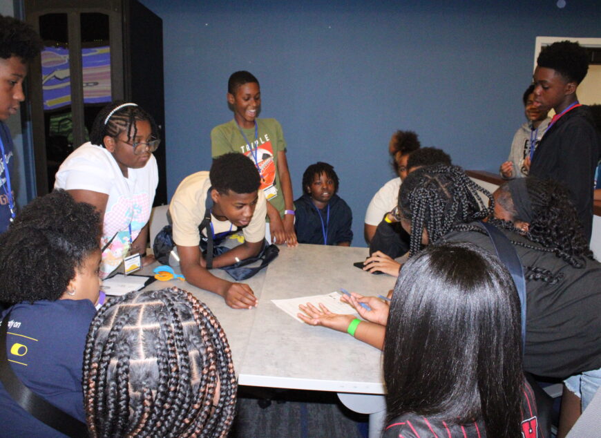 Group of students interacting and laughin in a classroom.