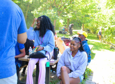 Group of students sitting outside at a picnic table.