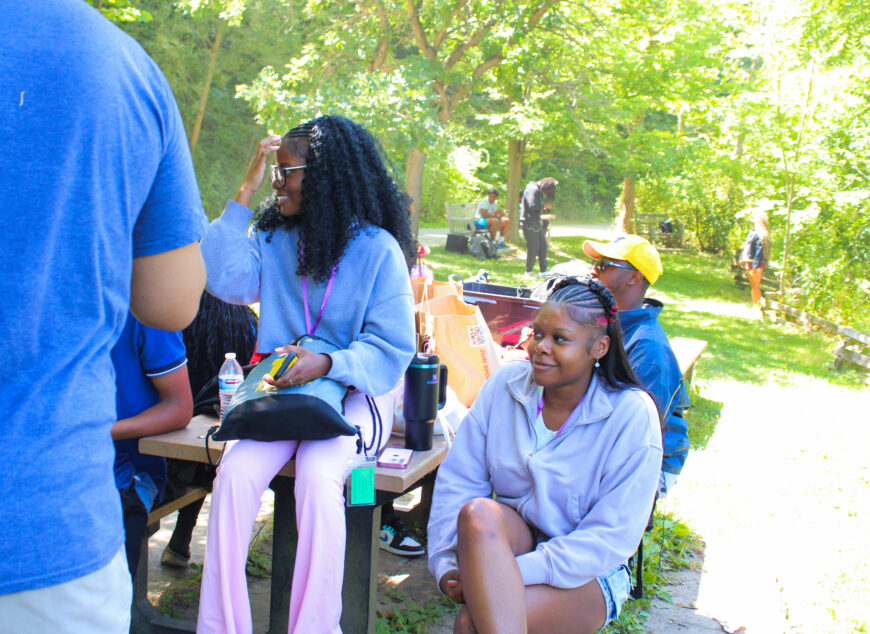 Group of students sitting outside at a picnic table.