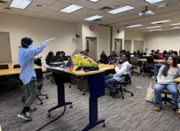 Group of students learning in a classroom at desks.