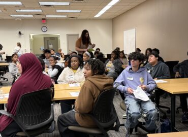 Group of students learning in a classroom at desks.