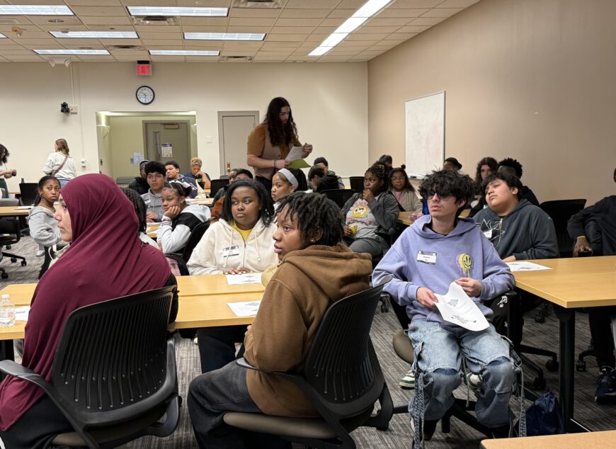 Group of students learning in a classroom at desks.