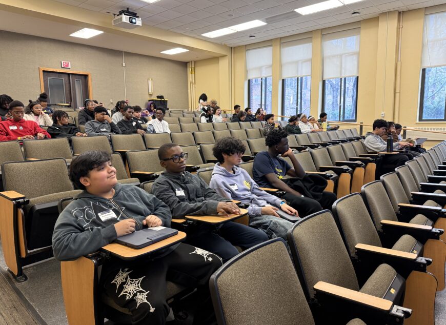 Group of students learning together in an auditorium.
