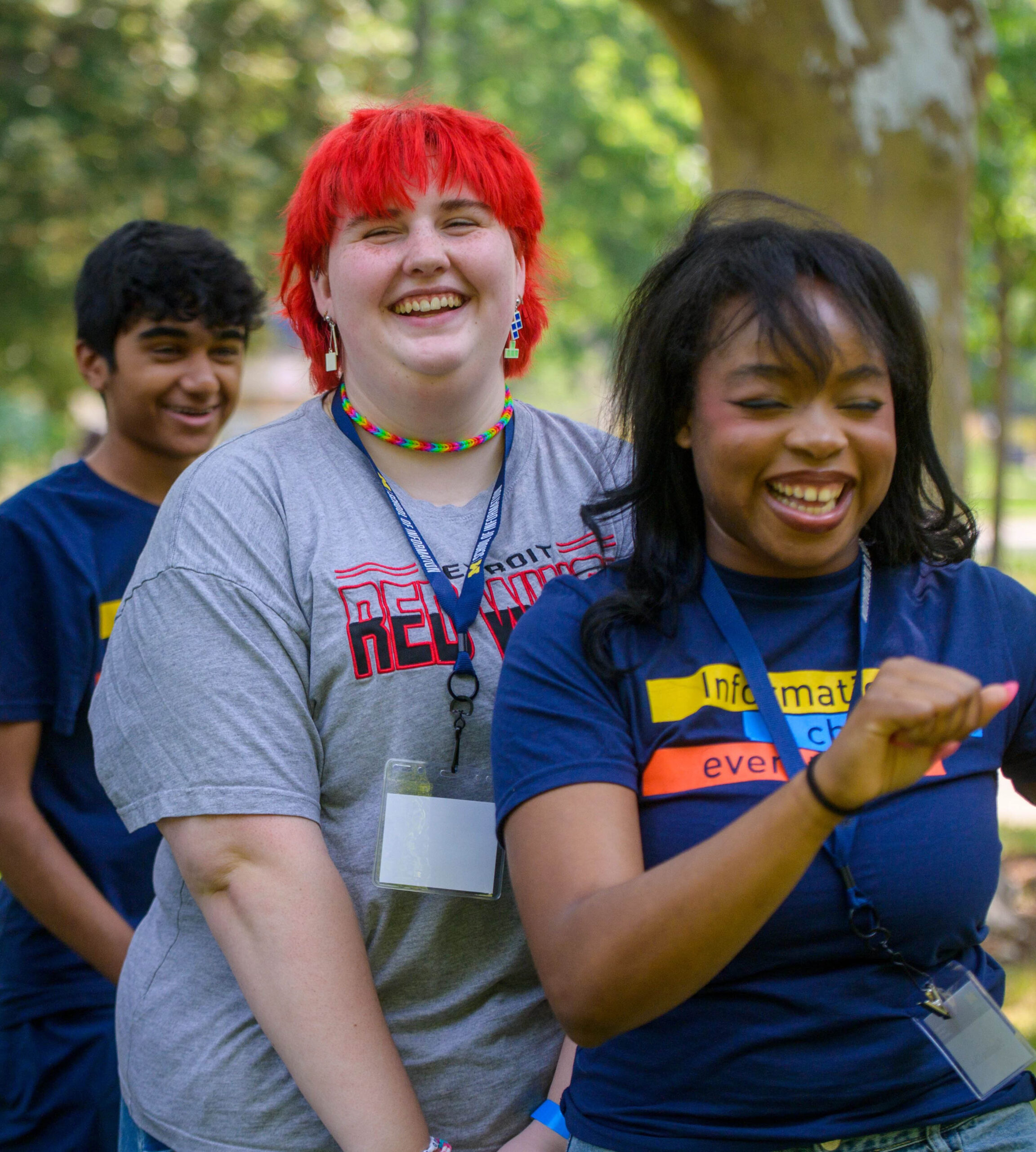 three people standing outside smiling
